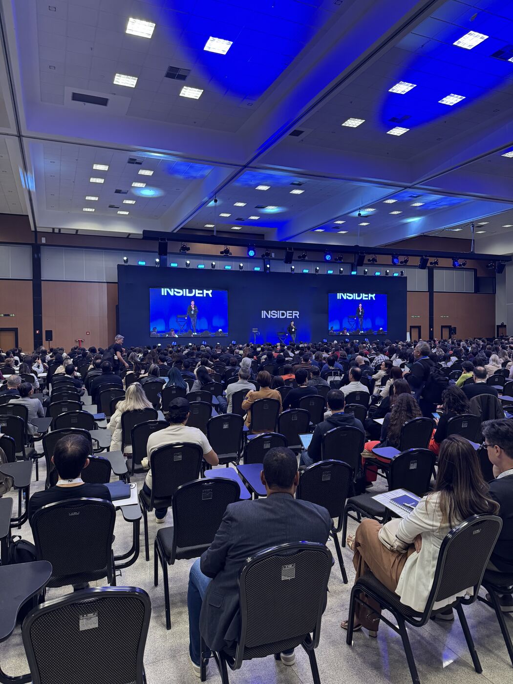 Auditório lotado do FL Insider, com o palco ao fundo