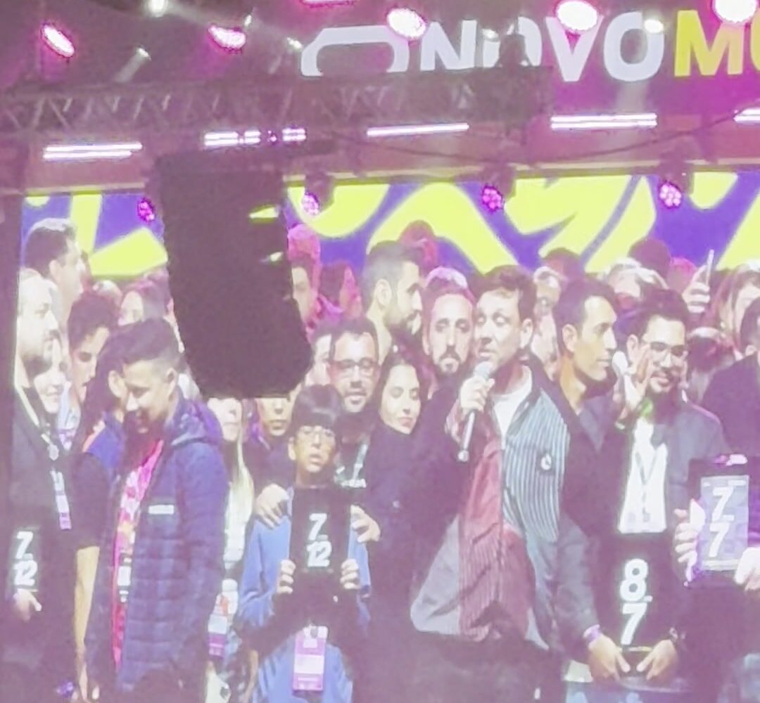 Telão mostra participantes no palco segurando as placas 7 em 7 e 8 em 7