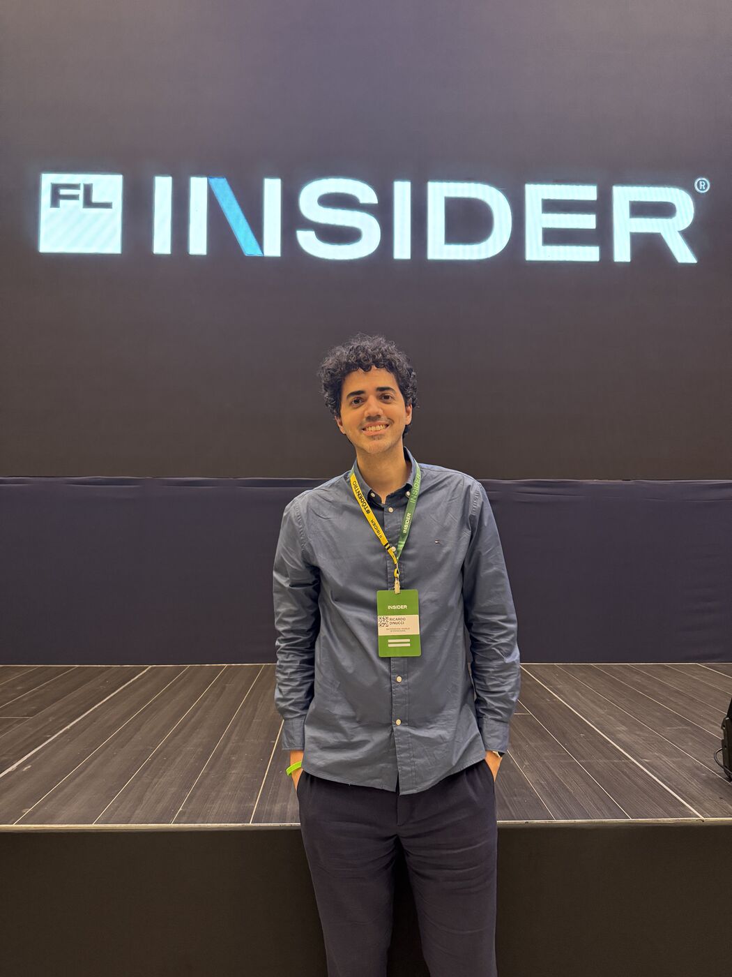 Ricardo Dinucci de crachá, em frente ao painel do FL Insider, em Brasília